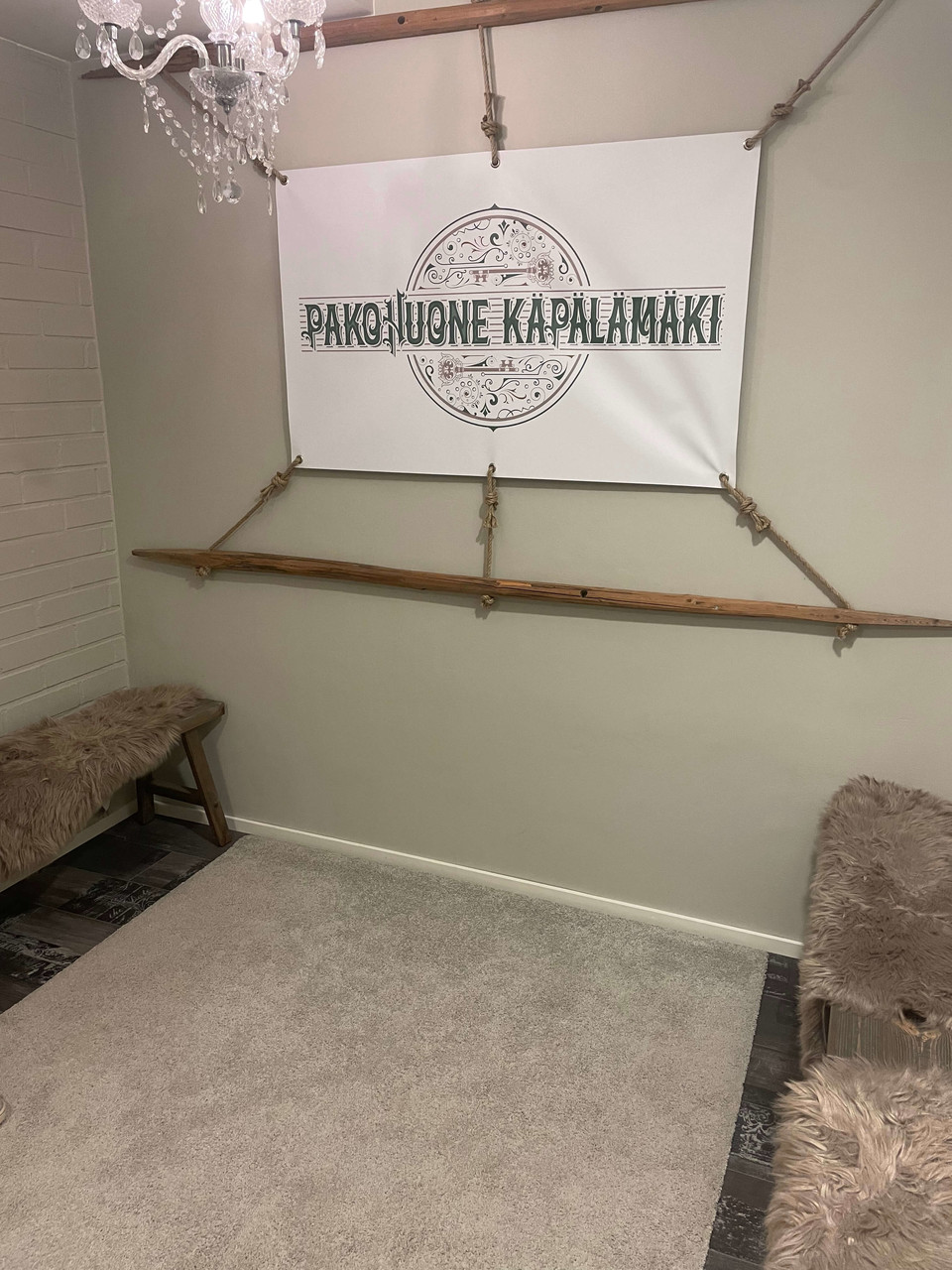 Pakohuone Käpälämäen aulaa koristavat taljoilla peitetyt penkit ja seinälle heinäseipäiden väliin viritetty yritystunnus.