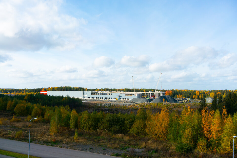Tokmannin pääkonttorin katolta kuvattu Tokmannin rakennustyömaalle  2022. Harmaa-punainen hallirakennus näkyy syksyisen puuston keskellä